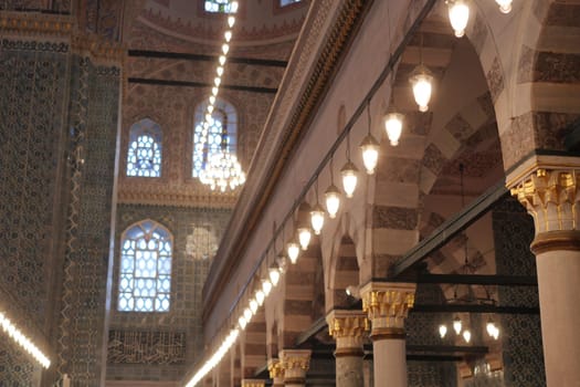 Stunning interior of a mosque showcases ornate arches and beautiful lights.