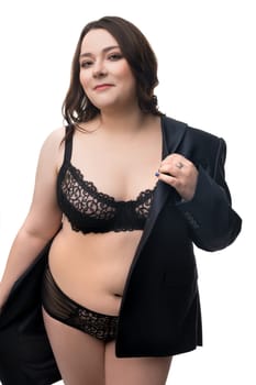 Smiling plus size female model wearing lace black lingerie and formal jacket looking at camera isolated on white background