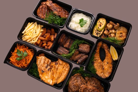 Fried meat and fish steak with vegetables and garnish in portions high angle view
