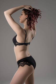 Young brunette in black lace lingerie cropped profile view