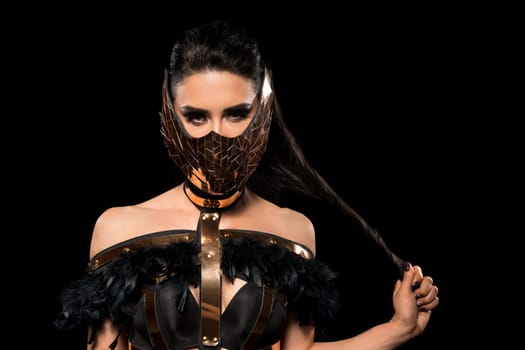 Brunette in bdsm style black lingerie and mask cropped view against black background