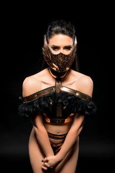 Gorgeous brunette in lace lingerie and bdsm gold mask shot against black background