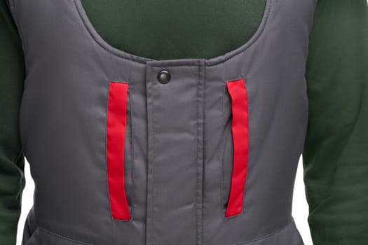Closeup of crop man in warm grey jumpsuit with red inserts on pockets on chest and green sweater isolated on white background