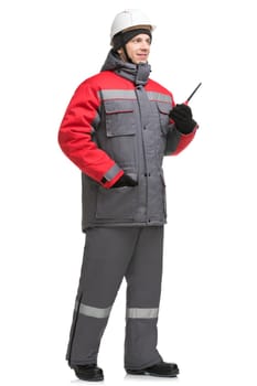 Male in winter workwear, cap and walkie-talkie isolated full-length view