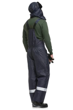 Man in blue work overalls and winter cap isolated full-length rearview