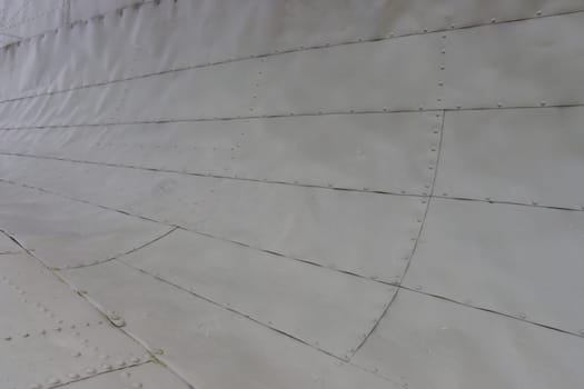 Abstract background of metal. The skin is made of metal sheets with rivets. The fuselage of the airplane.