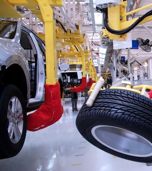 Robotic arms are actively assembling vehicles in a modern manufacturing facility, highlighting advanced production techniques and efficiency.