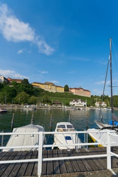 Meersburg, Germany – August 03, 2024: Boats at the pier of Meersburg on Lake Constance. The state winery, Staatsweingut in the background.