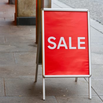 A display in front of a clothing store with the lettering Sale