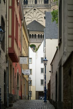 Cologne, Germany – May 24, 2024: View through the alley on the Rothenberg in Cologne to the Romanesque church of Groß St. Martin