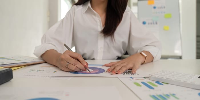 Business Asian woman at doing plan analyzing the financial report, business plan investment, finance analysis and tax the workplace.