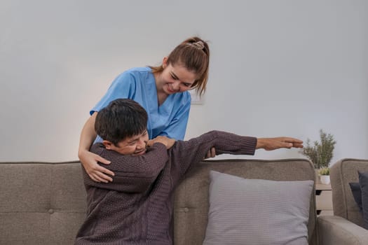 Nurse supports man during recovery and doing physical therapy, a senior resting in the living room and showing kindness while checking the health of a retired person at home.