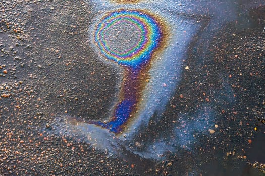 Gasoline or oil stains on an asphalt road as a texture or background.