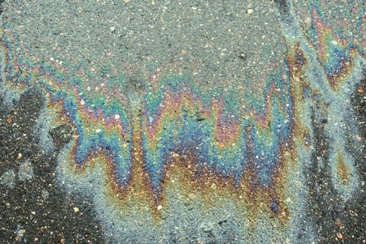 Spills of fuel or oil on the asphalt road as texture or background.