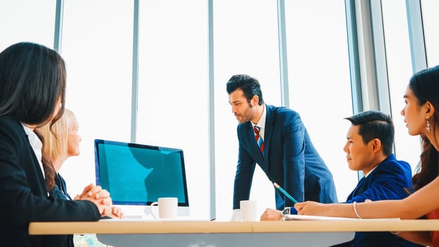 Business people in the conference room with green screen chroma key TV or computer on the office table. Diverse group of businessman and businesswoman in meeting on video conference call . Jivy