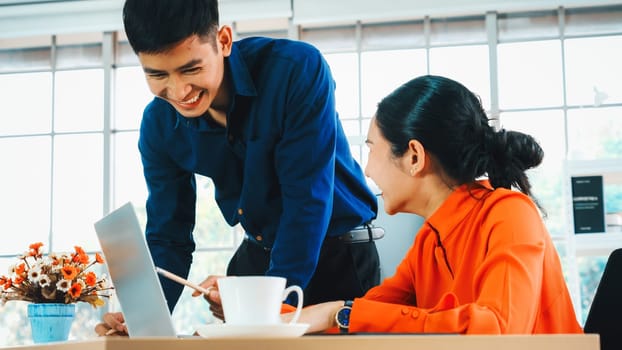 Two business people talk project strategy at office meeting room. Businessman discuss project planning with colleague at modern workplace while having conversation and advice on financial report. Jivy