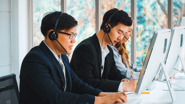 Business people wearing headset working in office to support remote customer or colleague. Call center, telemarketing, customer support agent provide service on telephone video conference call. Jivy