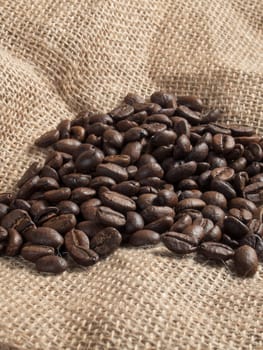 Brown roasted coffee beans on sackcloth.
