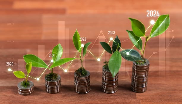 Growing young tree seedling planted on top of coin stack with ESG business investment with sustainable growth potential lead to profitable financial return and environmental protection. Reliance