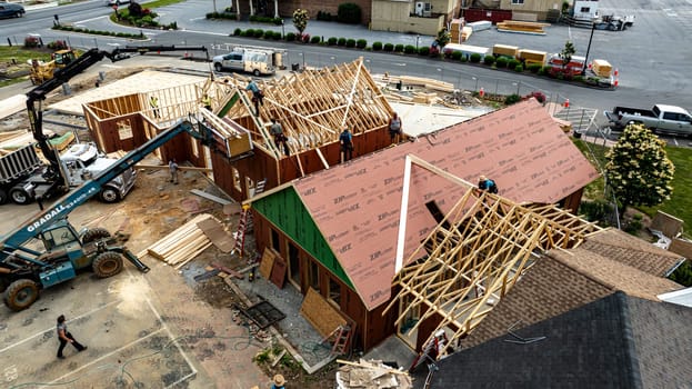 Bird in Hand, Pennsylvania, USA, June 6-2024 - Aerial View Of A Busy Construction Site With Wooden Framing And Building Materials On A Sunny Day, Surrounded By Green Fields, Residential Buildings.