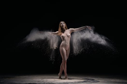 Full length naked woman throw dust in dark