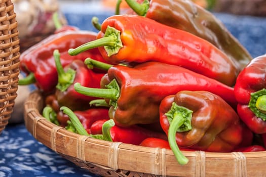 A basket of red bell peppers on display at a market.