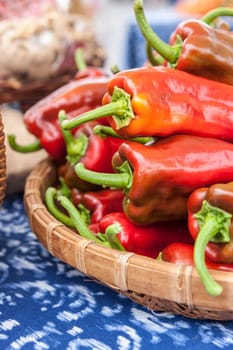 A basket of red bell peppers on display at a market.