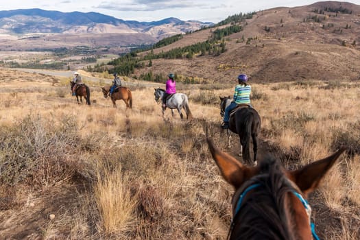 A family follows behind a guide on Sun Mountain near Winthrop, Washington.