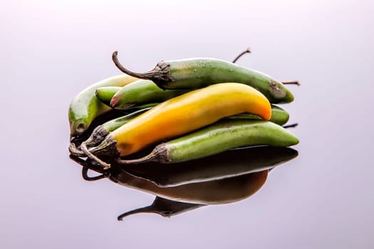 A close up studio image of a bunch of jalapeno peppers.
