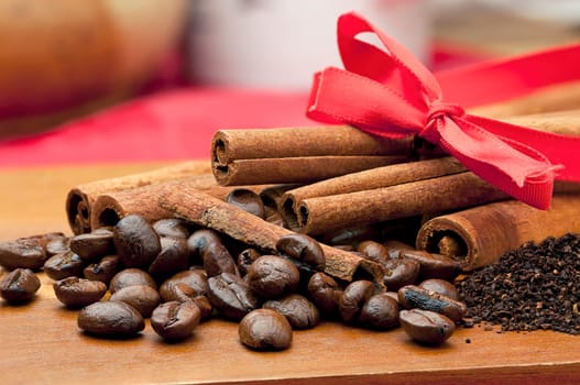 Close up of coffee beans, coffee, grounds, and cinnamon sticks.