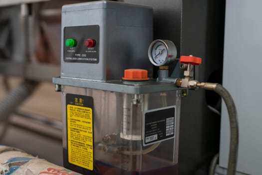 Compressor with pressure gauge mounted on automatic glass polishing machine in industrial workshop