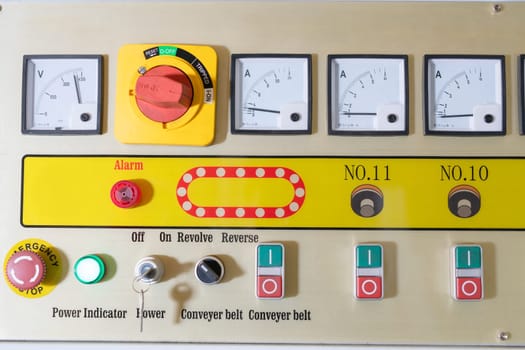 Various switches and buttons located near monitors on control panel of glass polish machine on factory