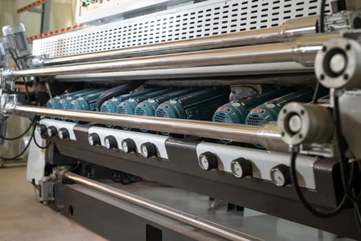 Metal construction with steel elements and spindle motors of automatic glass polishing machine in workshop