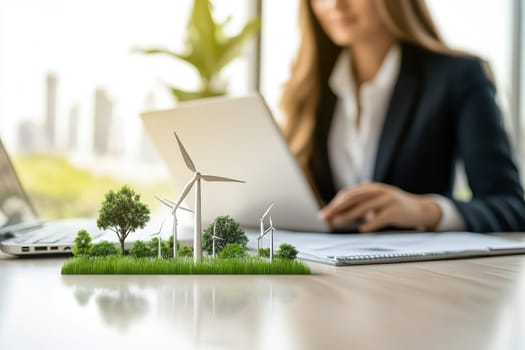A clean, modern workspace features a floating hologram showcasing nature elements like trees and wind turbines, signifying innovation and sustainability in business.