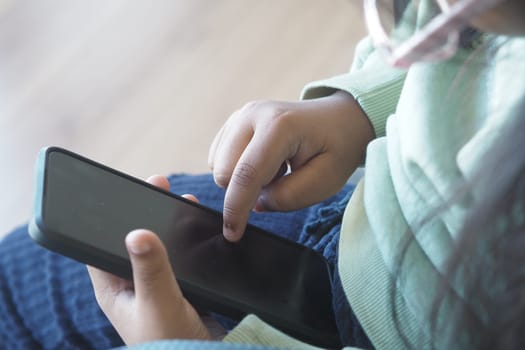 Young child engaging with a smartphone, focused on a touchscreen activity.