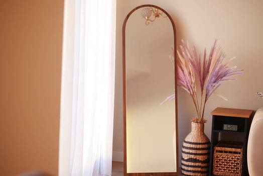 A full-length mirror and vibrant plant elevate the decor.