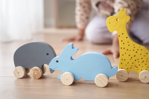 Brightly colored wooden toys shaped like animals attract a child's attention.