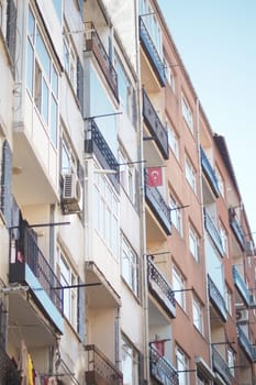 Vibrant apartment buildings display Turkish flags on balconies.