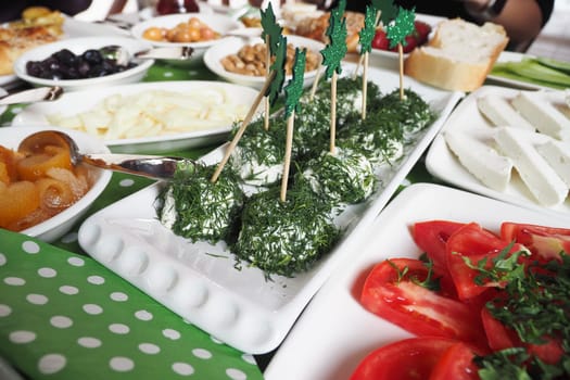 A colorful array of appetizers showcases herbs, cheese, and vegetables.