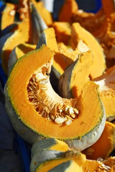 Bright orange pumpkin slices showcased for sale during fall harvest.