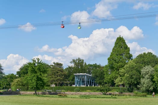 Cologne, Germany – May 23, 2024: the Rhine Park, Rheinpark with gondolas of the Rhine cable car, Rhein Seilbahn on a sunny day in Cologne