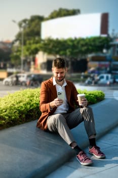 Young businessman using a smartphone outdoors in a modern urban.