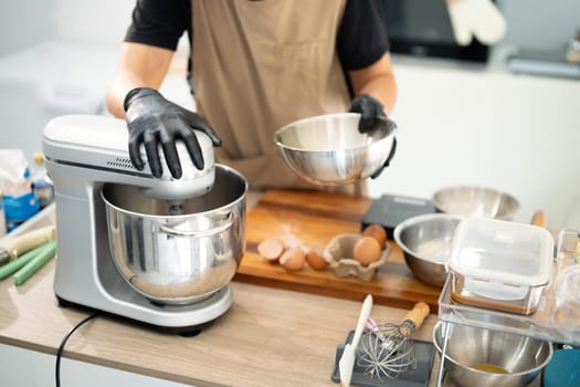 Male baker using a stand mixer to make cookie dough.