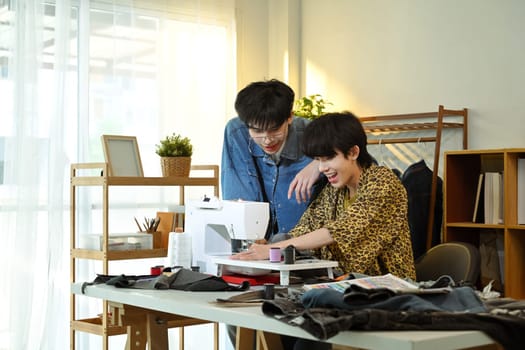 Happy designers working on a new clothing project in a bright fashion studio.