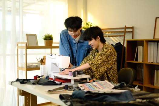 Young fashion entrepreneurs working on a denim project in a bright fashion studio.