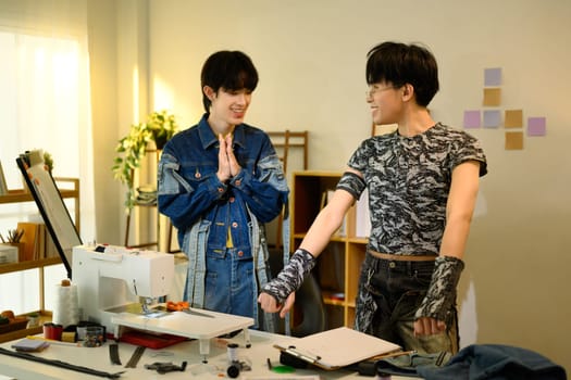 Creative fashion designers collaborating in a stylish workspace.