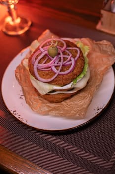 Juicy mouth-watering fatty burger made from grated potatoes and meat on the table in the restaurant.