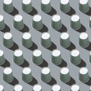 Disposable new light green paper cups on gray top view, hard shadow, pattern, mockup with copy space. Empty cardboard coffee cups flat lay. Consumerism concept