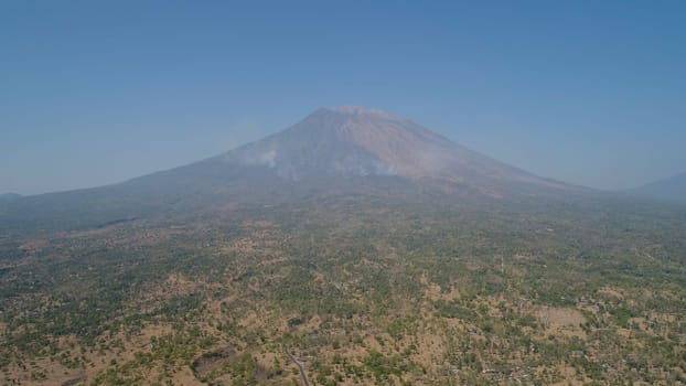 Aerial view volcano mount Agung Bali, Indonesia. tropical landscape savanna with low trees at foot volcano. Rural mountain landscape.