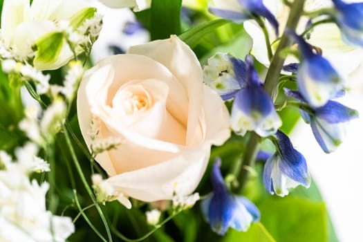 A stunning bouquet featuring fresh white roses and assorted flowers gracefully arranged in a vase, exuding timeless beauty.